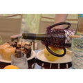 Purple mesh wine tote bag holding bottle, pouring wine at outdoor table with muffins and fruit