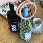 Wine bottle carriers with wooden handles and colorful netting, perfect for gifting or parties