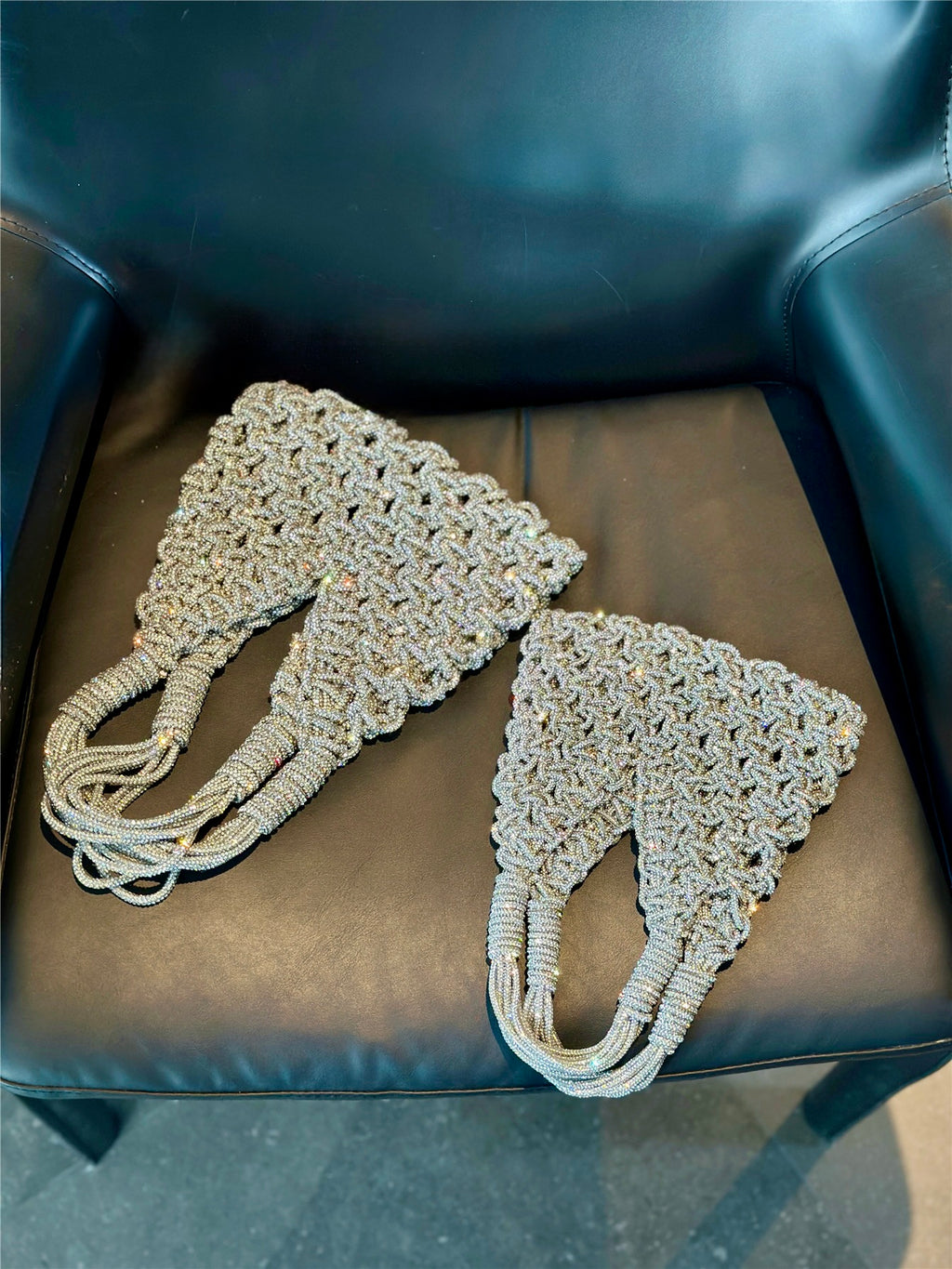 Sparkling rhinestone wine tote bags for luxury gifts, weddings, and parties, displayed on a black leather chair.