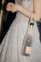 Elegant rhinestone wine tote bag held by woman in glittering gown, perfect for luxury celebrations and parties.