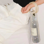 Sparkling rhinestone wine tote bag with clear handle, holding a bottle for elegant gifting or parties.